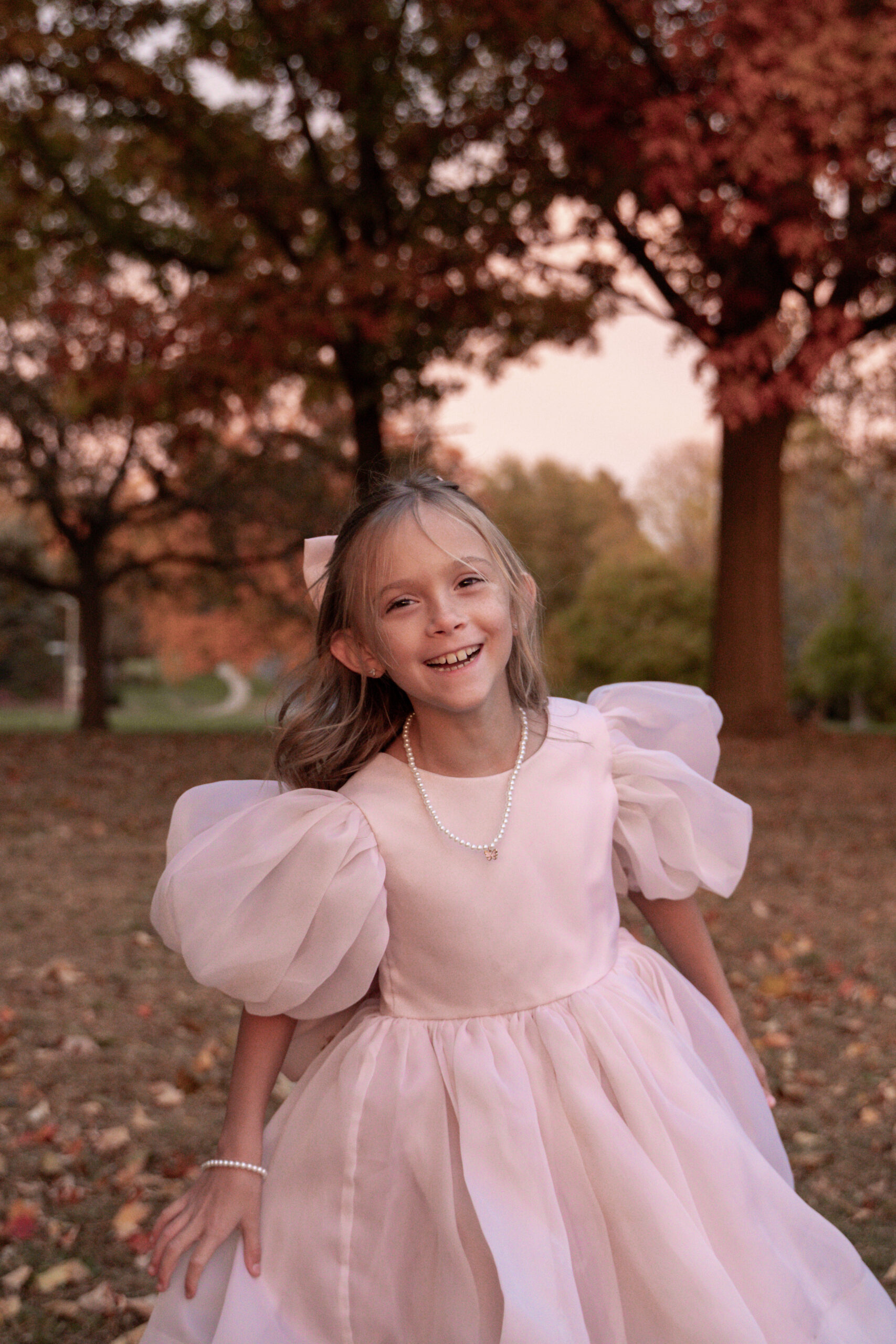 Child running toward the sunset under glowing fall trees in Davenport East Village