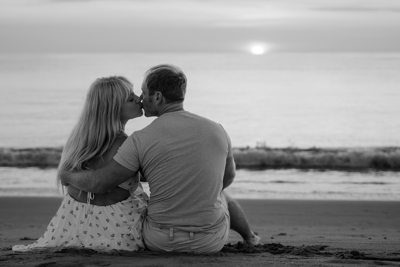 Couple holding hands in the waves at sunrise in Flagler Beach Florida