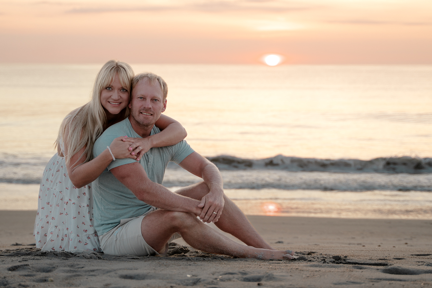 Romantic couple silhouette against pastel sunrise sky at Flagler Beach
