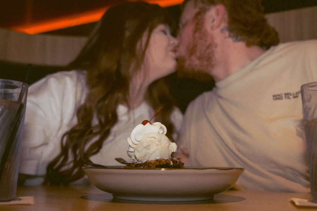Couple sharing a brookie sundae in a diner booth during Davenport Iowa engagement photos