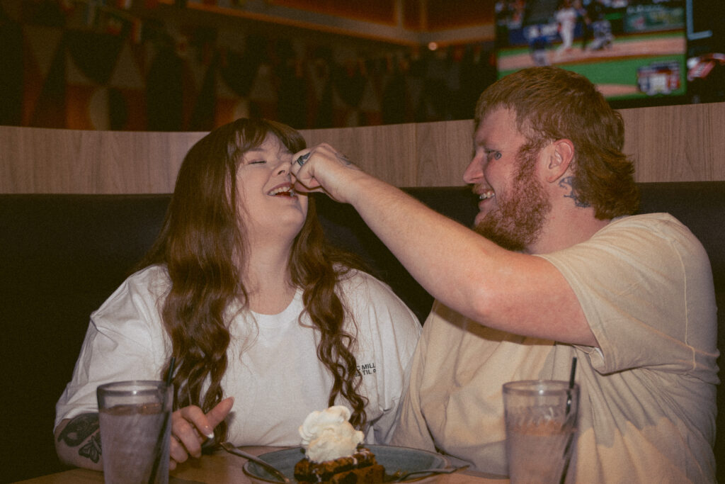 Couple sharing dessert in a diner booth during a Davenport Iowa engagement session