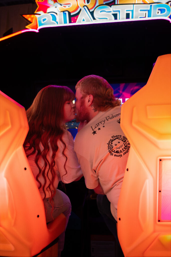 Couple playing arcade games during a fun engagement session in Davenport Iowa