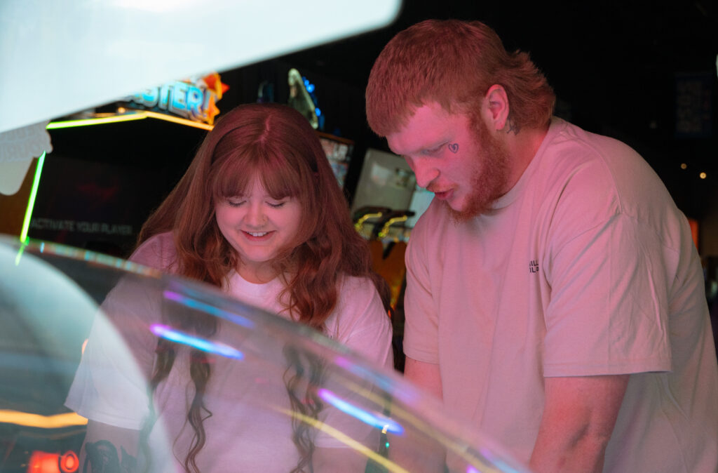 Couple playing arcade games during a fun engagement session in Davenport Iowa
