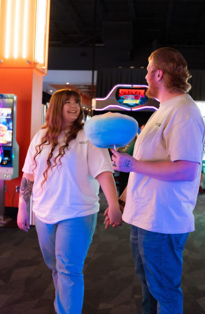 Couple playing arcade games during a fun engagement session in Davenport Iowa