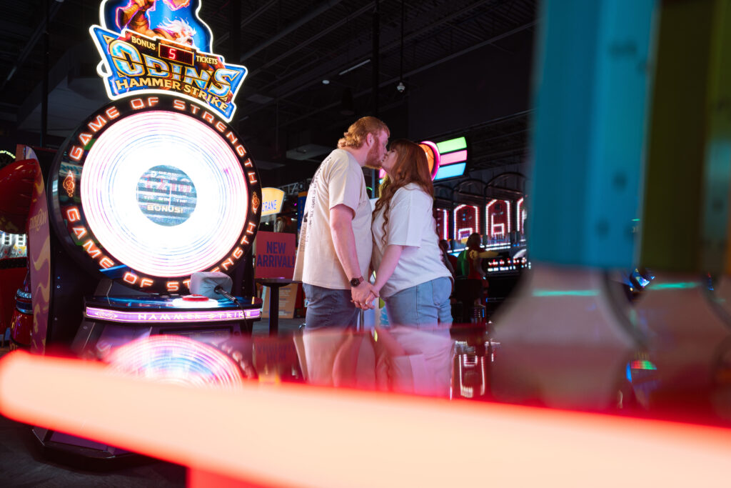 Couple playing arcade games during a fun engagement session in Davenport Iowa